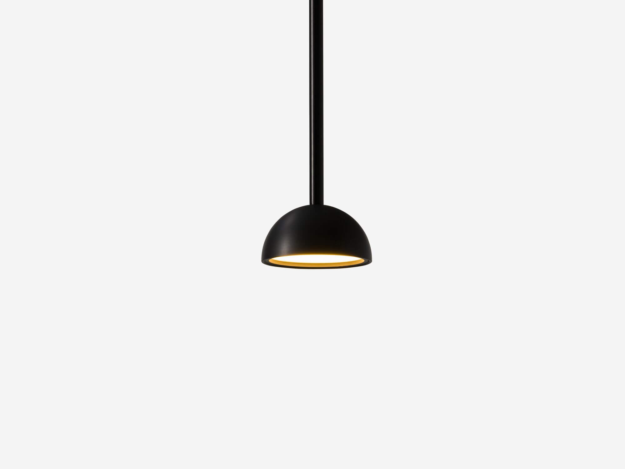 Black rounded pendant lamp with light on detail view